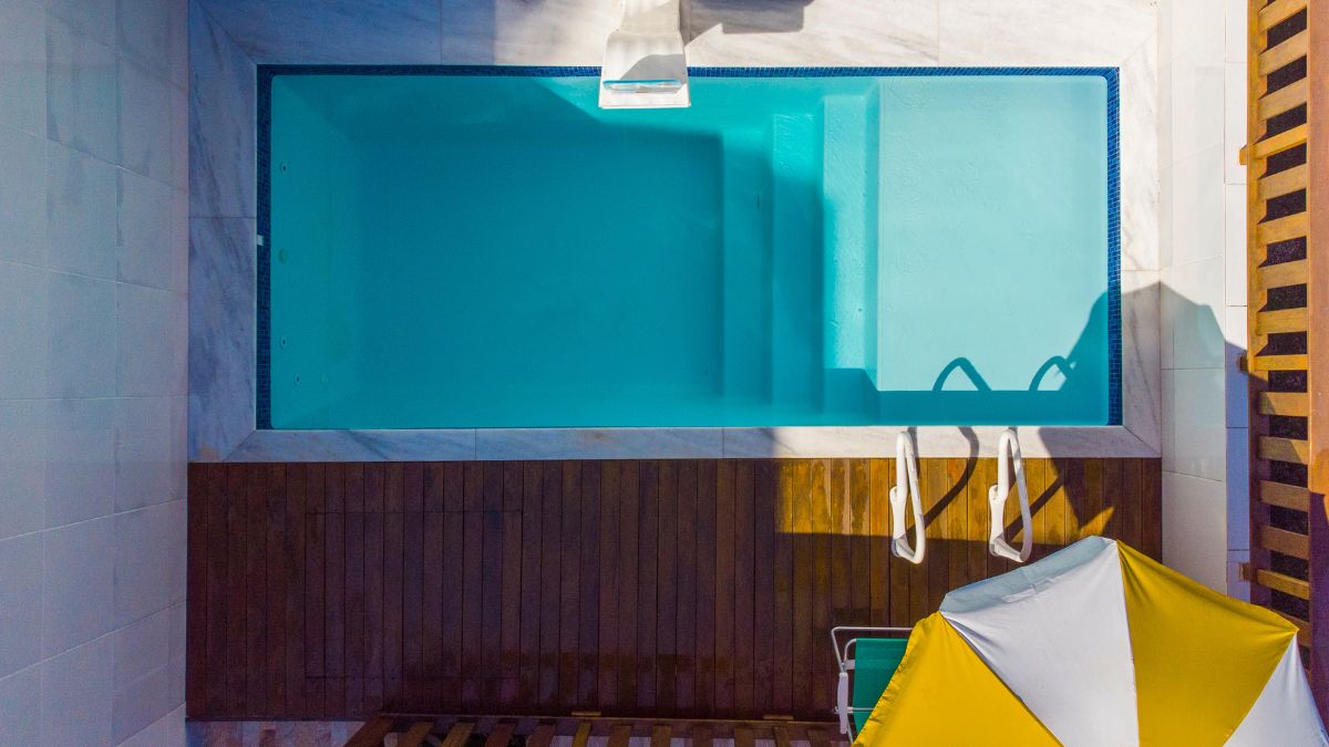 Piscina com deck de madeira e solarium